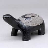 A black turtle figure decorated with a sgraffito kokopelli design
 by Corn Moquino of Santa Clara