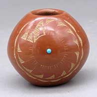 A miniature red jar decorated with a sgraffito geometric design and an inlaid stone
 by Juan Tafoya of San Ildefonso