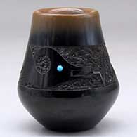 A small black jar with a sienna rim, an inlaid stone and a sgraffito avanyu design
 by Rose Lovato-Fragua of San Ildefonso