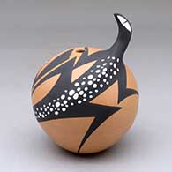 A polychrome seed pot decorated with a lizard applique and a painted lizard and geometric design
 by Anderson Peynetsa of Zuni