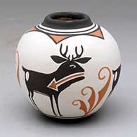 A small polychrome jar with a raised rim and a four panel deer with heart line and geometric design
 by Carlos Laate of Zuni