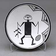 A shallow black on white bowl decorated with a fisherman, fish and geometric design
 by Emma Lewis of Acoma