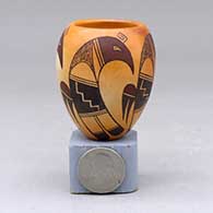 A miniature polychrome jar decorated around the body with a four panel bird element and geometric design
 by Dianna Tahbo of Hopi