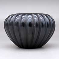 A black melon bowl with 24 carved ribs, click or tap to see a larger version