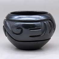 A black bowl carved with a stylized avanyu design around the body
 by Stella Chavarria of Santa Clara
