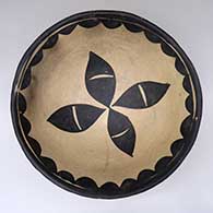 An open polychrome bowl decorated on the inside with a pumpkin seed and geometric design
 by Unknown of Cochiti