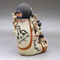 A polychrome sitting grandfather storyteller figure holding sixteen children with puppies, a drum and a ball, click or tap to see a larger version
