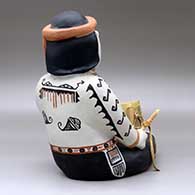 A sitting singing drummer figure decorated with a geometric design and holding a drum, click or tap to see a larger version