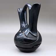 A black wedding vase carved around the body with an avanyu design, click or tap to see a larger version