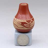 A miniature red jar decorated with a sgraffito avanyu design around the shoulder
 by Haungooah aka Art Cody of Santa Clara