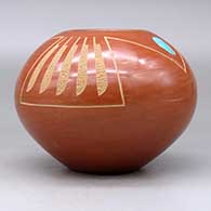 A red jar decorated with two pieces of inlaid turquoise and a sgraffito feather and geometric design, click or tap to see a larger version