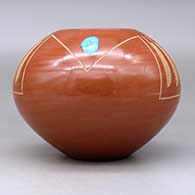 A red jar decorated with two pieces of inlaid turquoise and a sgraffito feather and geometric design, click or tap to see a larger version