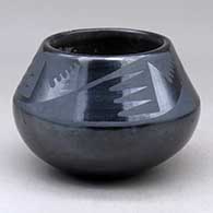 A black on black jar decorated with a four panel bat wing and geometric design above the shoulder
 by Maria Martinez of San Ildefonso