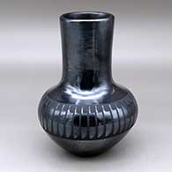 A black on black vase decorated around the shoulder with a band of feathers design
 by Maria Martinez of San Ildefonso