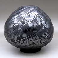 A black on black melon jar carved with eight spiral ribs and each rib decorated with Classic Mimbres animals and geometric designs, click or tap to see a larger version
