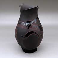 A polychrome jar with an organic cut opening and decorated with a sickle, feather and geometric design
 by Lydia Quezada of Mata Ortiz and Casas Grandes