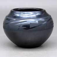 A black on gunmetal black bowl decorated with a four-panel geometric design around the shoulder
 by Desideria Montoya of San Ildefonso
