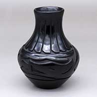 A black water jar carved with an avanyu and ring-of-feathers design
 by Denise Chavarria of Santa Clara