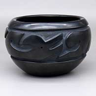 A black bowl with an avanyu design carved around the body
 by Betty Tafoya and Lee Tafoya of Santa Clara