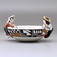 A polychrome friendship bowl with two boys on the rim, a dog, turtle and birds inside and decorated with a fineline and geometric design, click or tap to see a larger version
