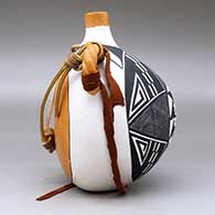 A polychrome flat-back canteen with twisted handles and decorated on the face with a fineline and geometric design, click or tap to see a larger version