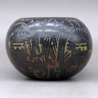 A polychrome bowl decorated with a sgraffito and colored kachina, mudhead, kokopelli, Mimbres insect and animal, and geometric design, click or tap to see a larger version