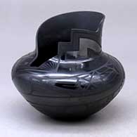 A black on black on black jar with a kiva step cut opening and decorated with a geometric design
 by Virginia Baca and Salvador Baca of Mata Ortiz and Casas Grandes