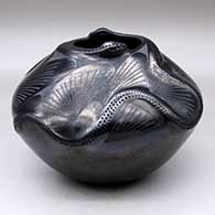 A black on black jar decorated with a pair of serpent appliques spiraling from the rim to the shoulder with geometric design in between
 by Yolanda Lopez of Mata Ortiz and Casas Grandes