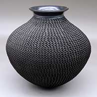 A black jar with a polished, rolled lip and a corrugated body
 by Jacobo Tena of Mata Ortiz and Casas Grandes