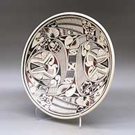 A large, shallow polychrome bowl decorated on top with a bird, butterfly and geometric design, click or tap to see a larger version