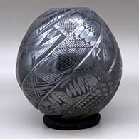A black on black spiraled repousse melon jar with eight ribs decorated with fish, birds, rabbits and geometric design on the ribs, click or tap to see a larger version
