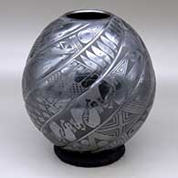 A black on black spiraled repousse melon jar with eight ribs decorated with fish, birds, rabbits and geometric design on the ribs
 by Macario Ortiz of Mata Ortiz and Casas Grandes