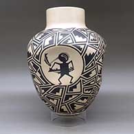 A large black on tan jar with four indented sides, each indent decorated with a different Mimbres cloudeater, and the rest of the body of the pot decorated with a geometric design, click or tap to see a larger version