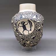 A large black on tan jar with four indented sides, each indent decorated with a different Mimbres cloudeater, and the rest of the body of the pot decorated with a geometric design, click or tap to see a larger version