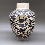 A large black on tan jar with four indented sides, each indent decorated with a different Mimbres cloudeater, and the rest of the body of the pot decorated with a geometric design, click or tap to see a larger version