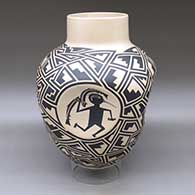 A large black on tan jar with four indented sides, each indent decorated with a different Mimbres cloudeater, and the rest of the body of the pot decorated with a geometric design
 by Martin Cota of Mata Ortiz and Casas Grandes