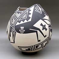 A large black on tan jar with a geometric cut opening and decorated with a variety of Mimbres wildlife, humans and geometric designs, click or tap to see a larger version