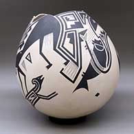 A large black on tan jar with a geometric cut opening and decorated with a variety of Mimbres wildlife, humans and geometric designs, click or tap to see a larger version