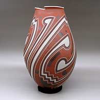 A tall polychrome jar with a geometric cut opening and a three panel lightly carved and painted geometric design, click or tap to see a larger version