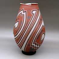 A tall polychrome jar with a geometric cut opening and a three panel lightly carved and painted geometric design, click or tap to see a larger version