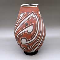 A tall polychrome jar with a geometric cut opening and a three panel lightly carved and painted geometric design
 by Tavo Silveira of Mata Ortiz and Casas Grandes