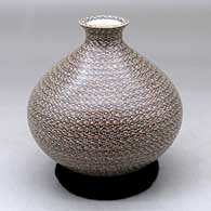 A polychrome jar with a tiny flared opening and decorated all over with bands of tiny geometric design
 by Elvira Bugarini of Mata Ortiz and Casas Grandes