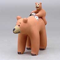 A standing bear with a cub holding a fish on its back, click or tap to see a larger version