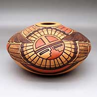 A polychrome seed pot jar decorated with a lightly carved and painted eagle dancer, sun kachina, bird element and geometric design, click or tap to see a larger version