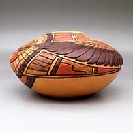 A polychrome seed pot jar decorated with a lightly carved and painted eagle dancer, sun kachina, bird element and geometric design, click or tap to see a larger version