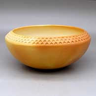 A large yellowware bowl polished inside and decorated above the shoulder with a corrugated geometric design
 by Larson Goldtooth of Hopi