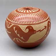 A red seed pot decorated with a sgraffito double avanyu, feather and cloud geometric design
 by Alvina Yepa of Jemez