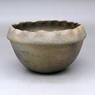 A golden micaceous bowl with a pie crust rim and fire clouds
 by Cordelia Gomez of Pojoaque