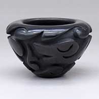 A small black bowl carved with an avanyu and geometric design around the outside
 by Victor and Naomi Eckleberry of Acoma