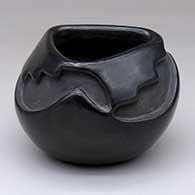 A black bowl with a triangular opening and carved with a three-panel kiva step and geometric design
 by Flora Naranjo of Santa Clara